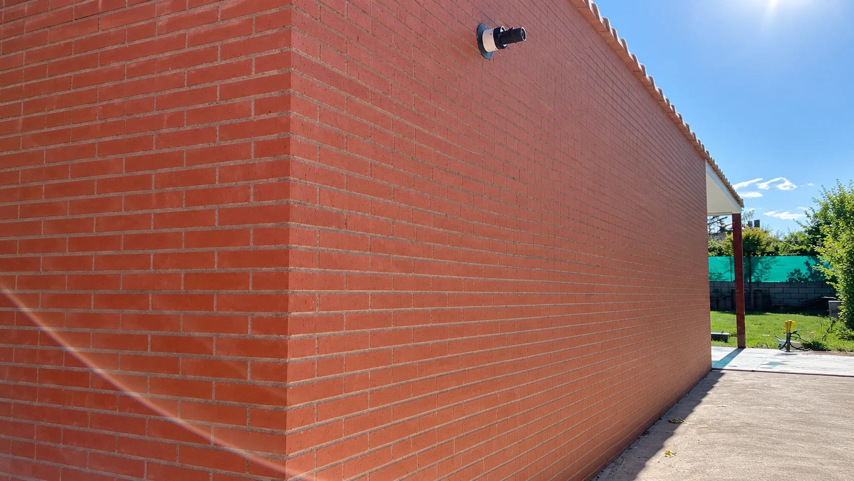 Fachada de ladrillo junto a una zona de jardín